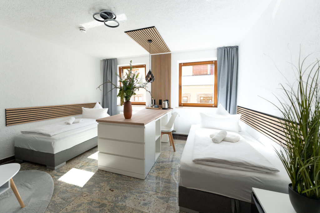 Zweibettzimmer mit moderner Einrichtung und Schreibtisch