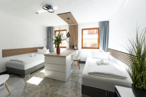 Zweibettzimmer mit moderner Einrichtung und Schreibtisch