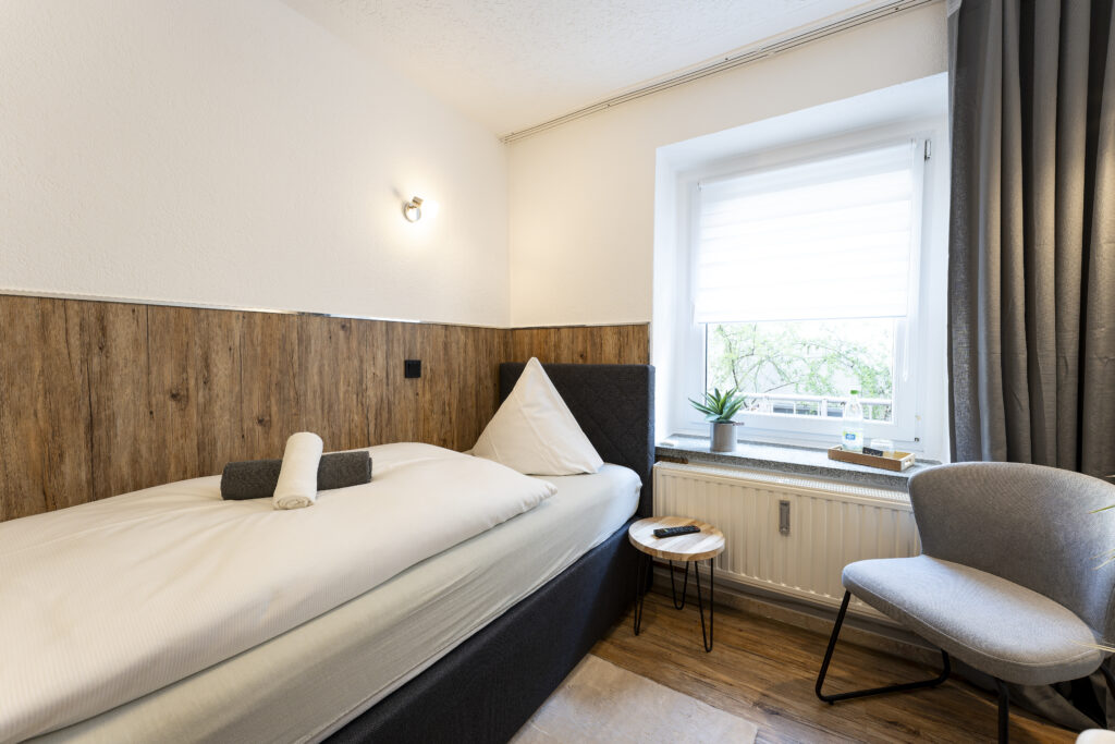 Blick in Zimmer 2, Einzelzimmer mit Bett und Sessel
