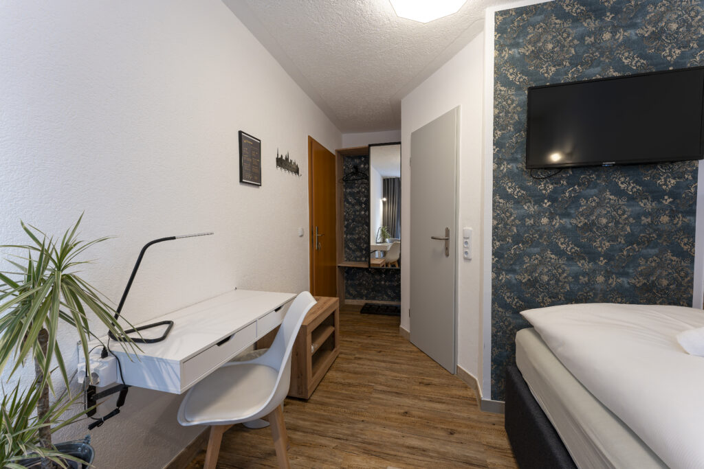 Blick in Zimmer 2, Wandschrank und Schreibtisch