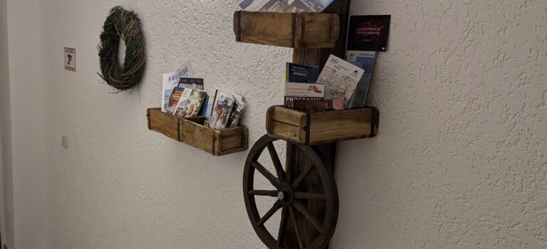 Infostand im Eingangsbereich mit Flyern und Prospekten