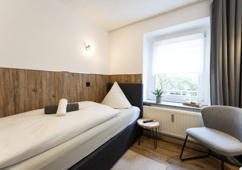 Blick in Zimmer 2, Einzelzimmer mit Bett und Sessel