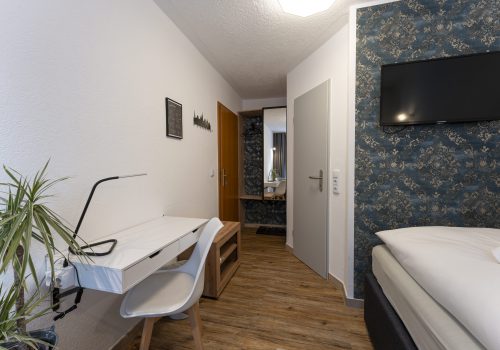 Blick in Zimmer 2, Wandschrank und Schreibtisch